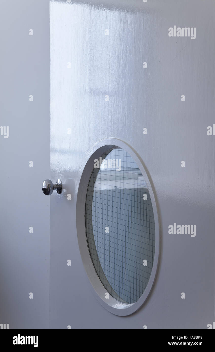 Innentür mit einem Bullauge Fenster am hohen Kreuz Haus, Dartington, Devon. High Cross House wurde im Jahre 1932 von WE Lescaze, Howe und Lescaze of America, in internationalen modernen Stil gebaut. Stockfoto