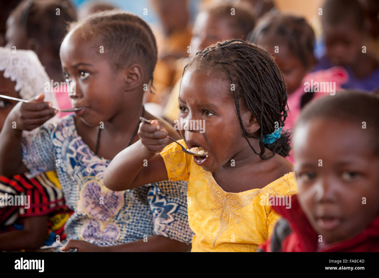 Kindergartenkinder Essen zu Mittag in der Kouka Primary School in Kouka Abteilung, Burkina Faso. Stockfoto