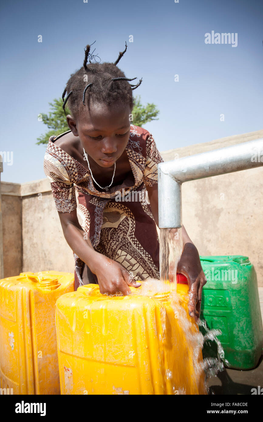 Mädchen bekommen frisches Wasser aus einem Brunnen in Kouka Abteilung in Burkina Faso, W. Afrika. Stockfoto