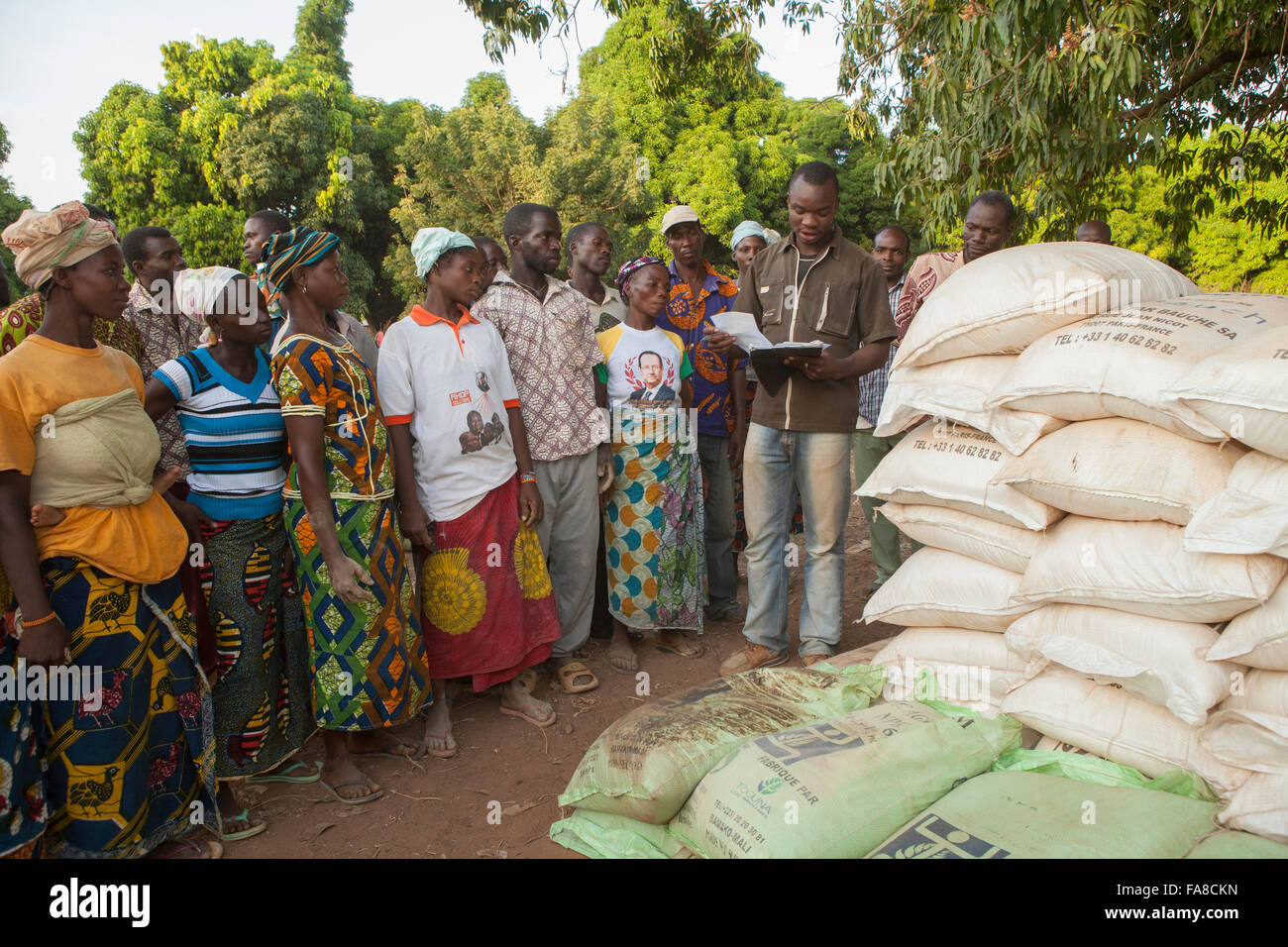 Kleinbauern erhalten Säcke von Saatgut und Dünger auf eine Verteilung in Banfora Abteilung, Burkina Faso. Stockfoto