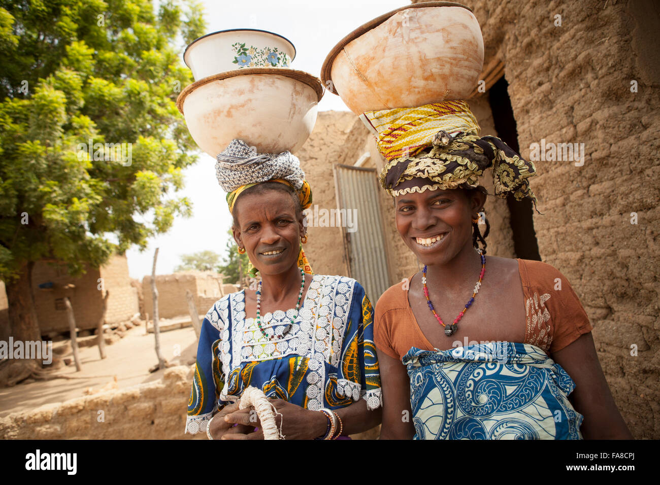 Frauen tragen Schüsseln auf dem Kopf in der Sourou Provinz in Burkina Faso. Stockfoto