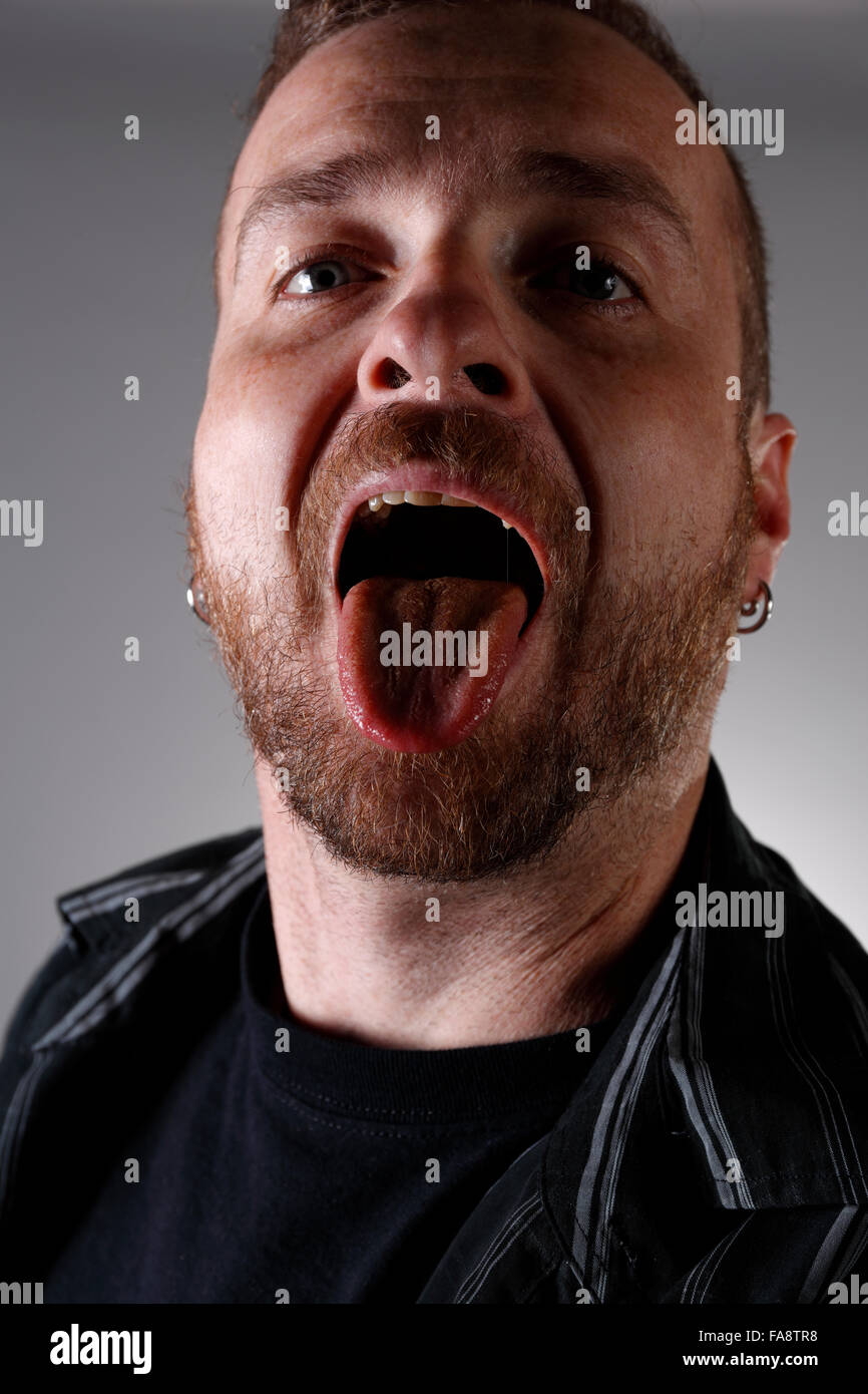 Mann mit offenem Mund, die Zunge zeigen. Stockfoto