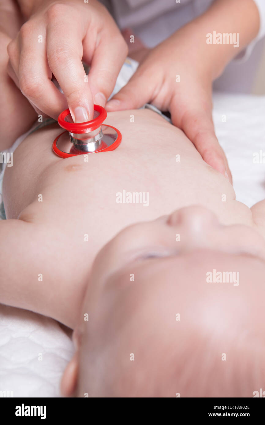 Kinderarzt im weißen Kittel untersucht drei Monate Baby Boy mit einem Stethoskop Stockfoto