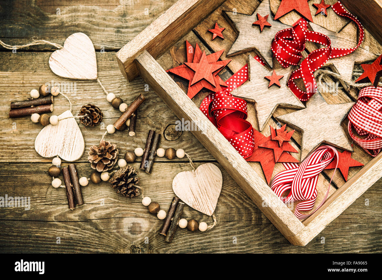 Weihnachtssterne Dekorationen aus Holz und roten Bändern. Nostalgisches Retro-Stil dunkel getönten Bild Stockfoto
