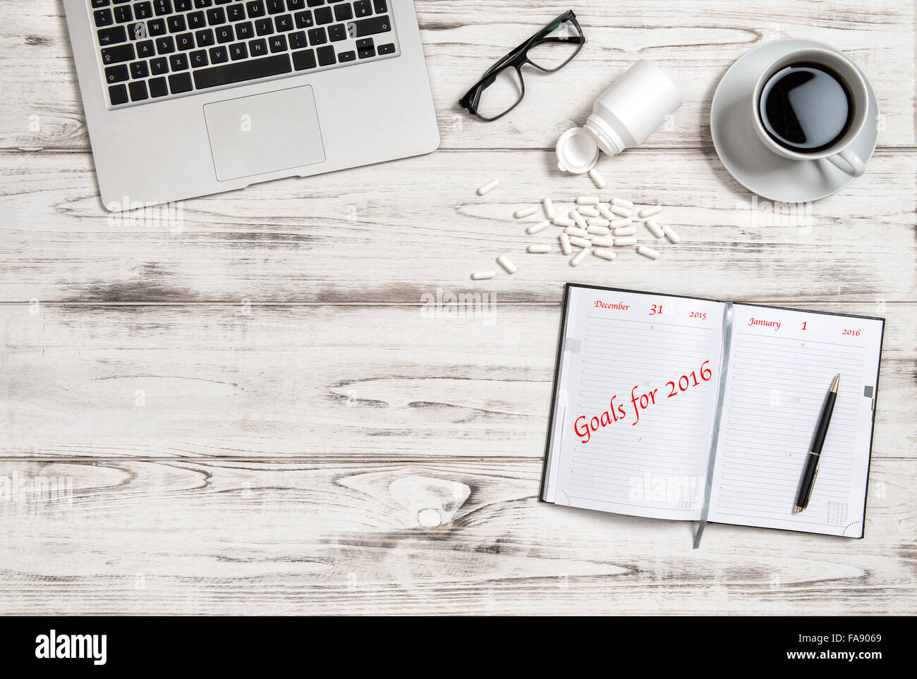 Büroarbeitsplatz mit Kalender-Buch, Kaffee und Medizin-Kapseln. Business-Konzept Ziele für das Jahr 2016 Stockfoto