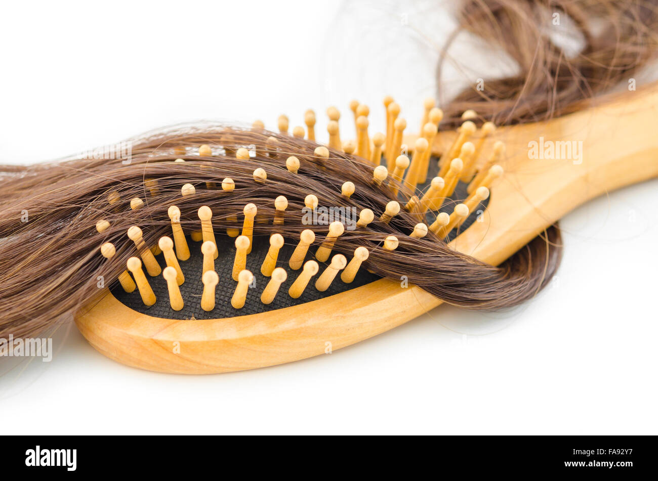 Haar-Verlust-Problem-Konzept. Hölzerne Haarbürste und Haare fallen auf weißem Hintergrund. Stockfoto