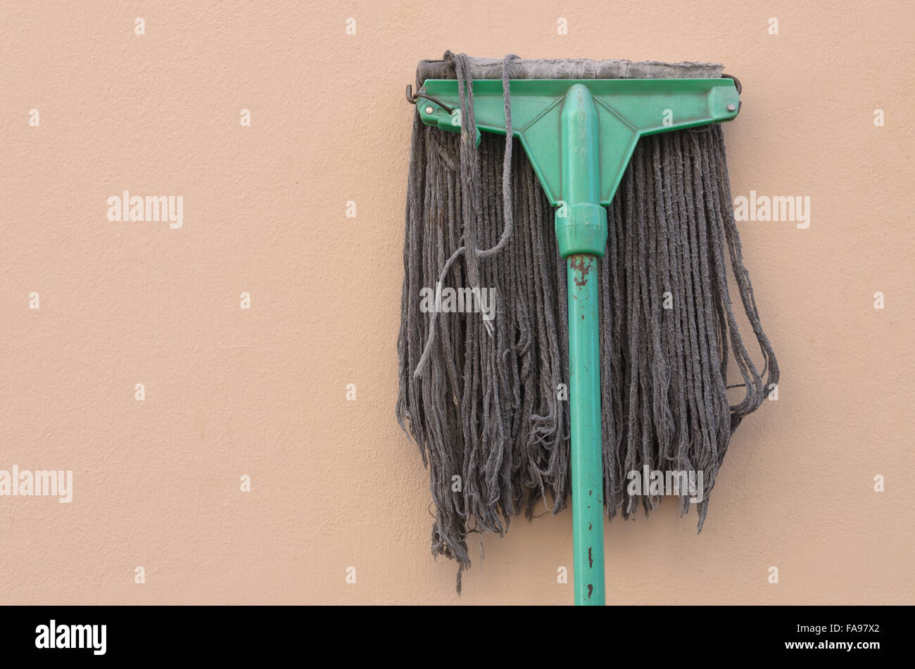 Alten Mop Rosa Wand liegen. Stockfoto