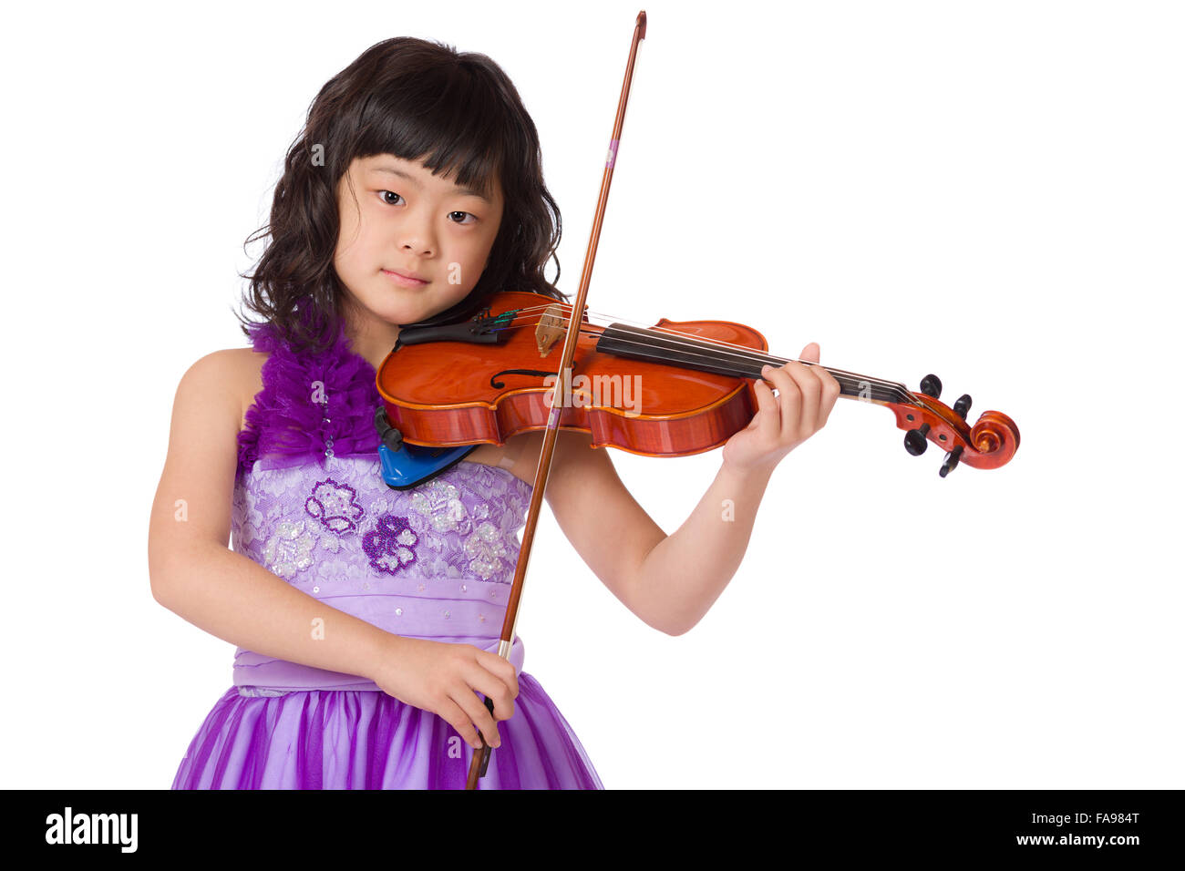 Ein Porträt einer niedlich, fröhlich und junge Japanerin in einem lila Kleid auf einem weißen Hintergrund mit einer Geige. Stockfoto