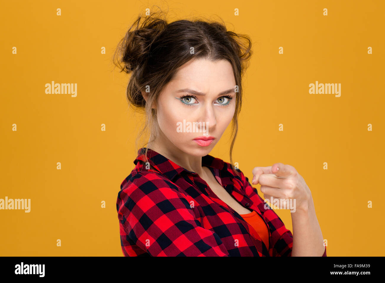 Nahaufnahme Portrait wütend irritiert jungen Frau im karierten Hemd zeigen Sie auf gelbem Hintergrund Stockfoto