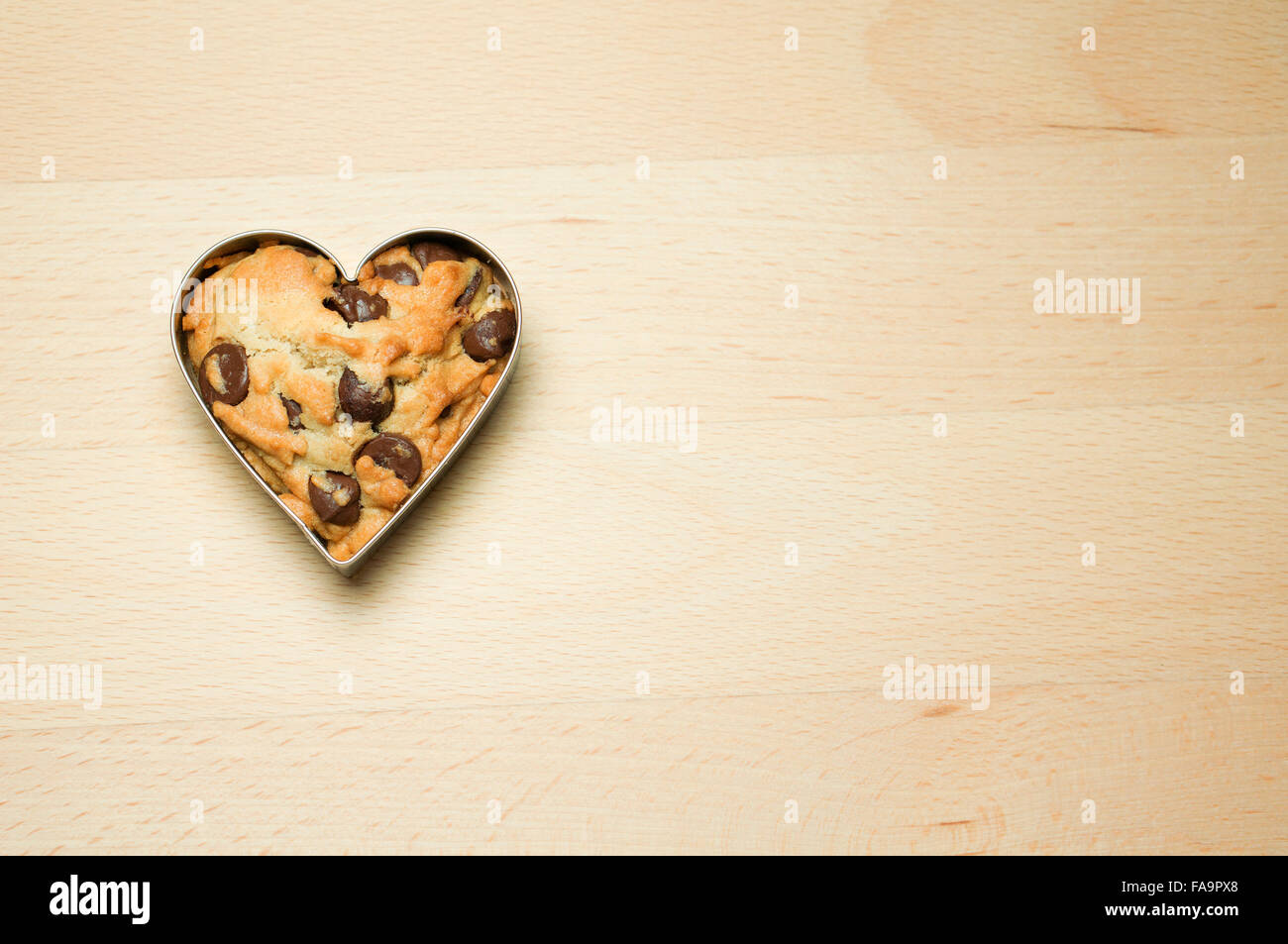 Cookie in Herzform auf Holztisch Stockfoto
