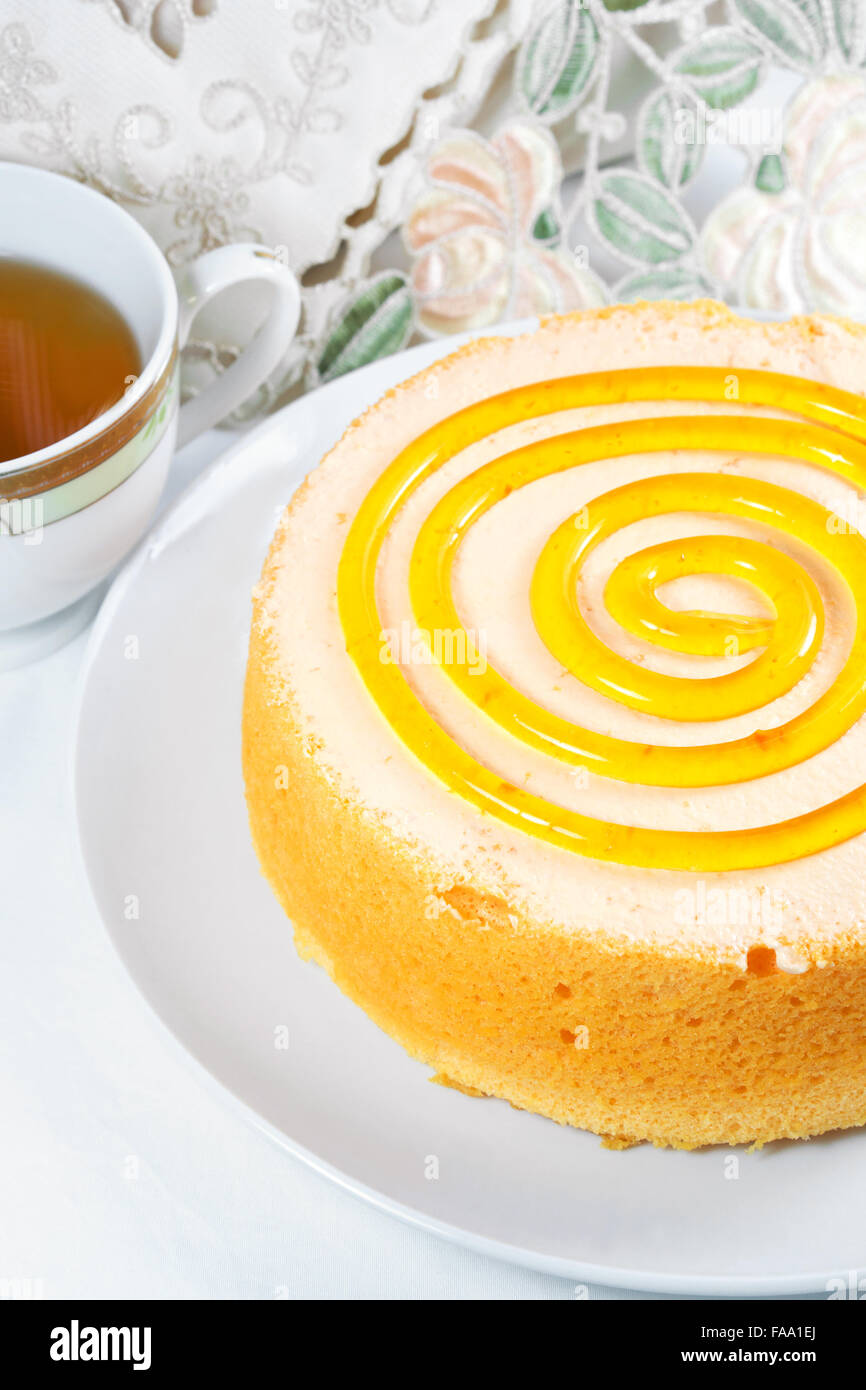 Schwamm orange Kuchen Dessert mit Tee auf Tisch Stockfoto