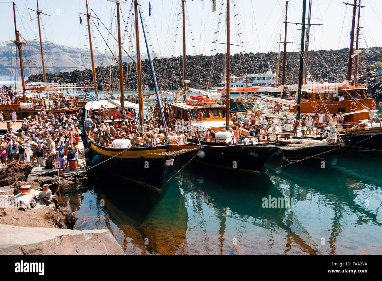 Santorini. Erinia Bay, Nea Kameni. Ausflug Boote am Steg vertäut verpackt mit Massen von Touristen Ein- und Aussteigen auf dem Vulkan besuchen. Stockfoto Santorini. Erinia Bay, Nea Kameni. Ausflug Boote am Steg vertäut verpackt mit Massen von Touristen Ein- und Aussteigen auf dem Vulkan besuchen. Stockfoto