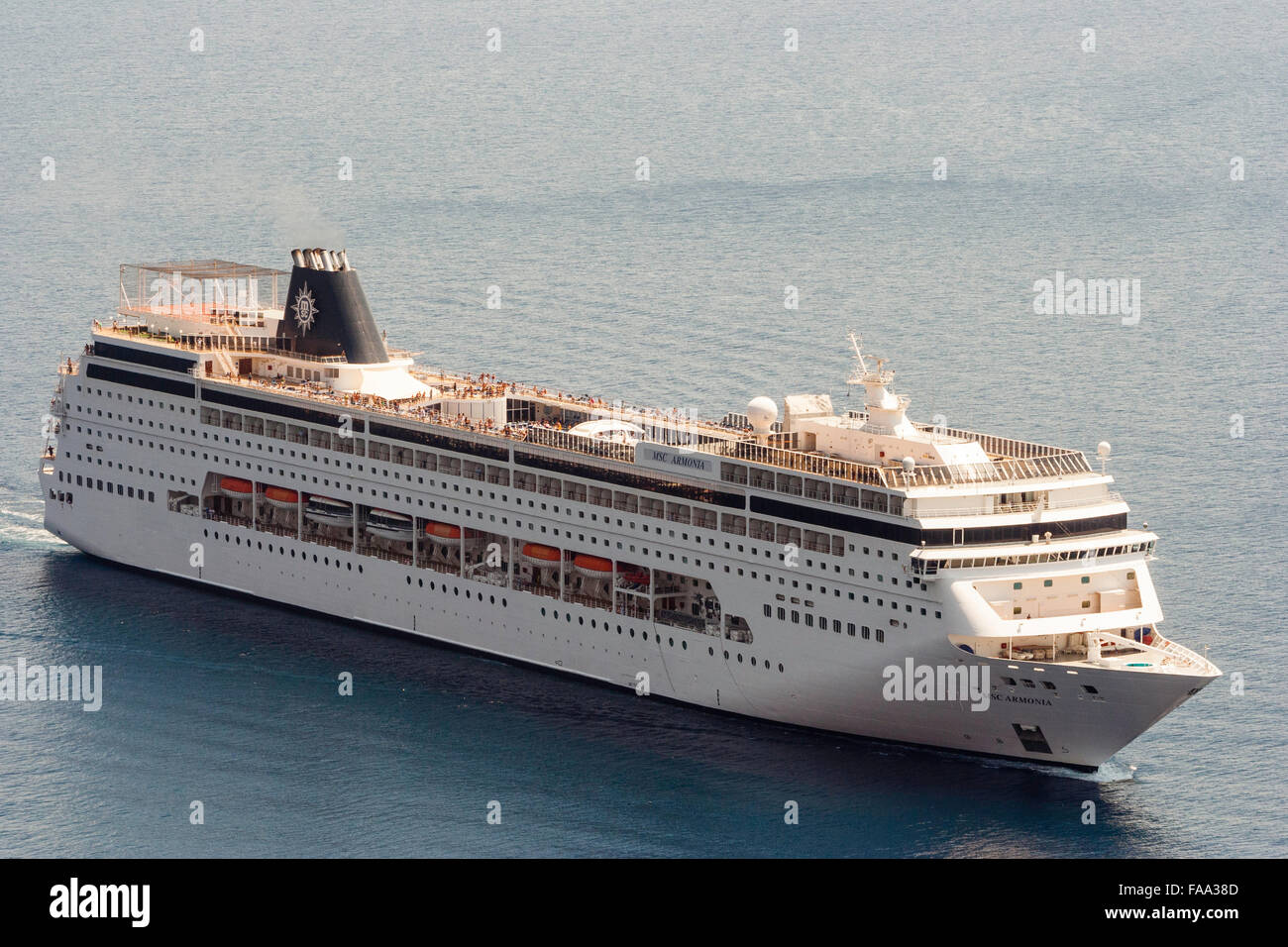 Ägäis, Santorini. Ocean-going Luxus Kreuzfahrtschiff MSC Armonia, voller Menschen, Segeln auf sehr ruhigen Meer. Luftaufnahme, strahlendem Sonnenschein. Stockfoto