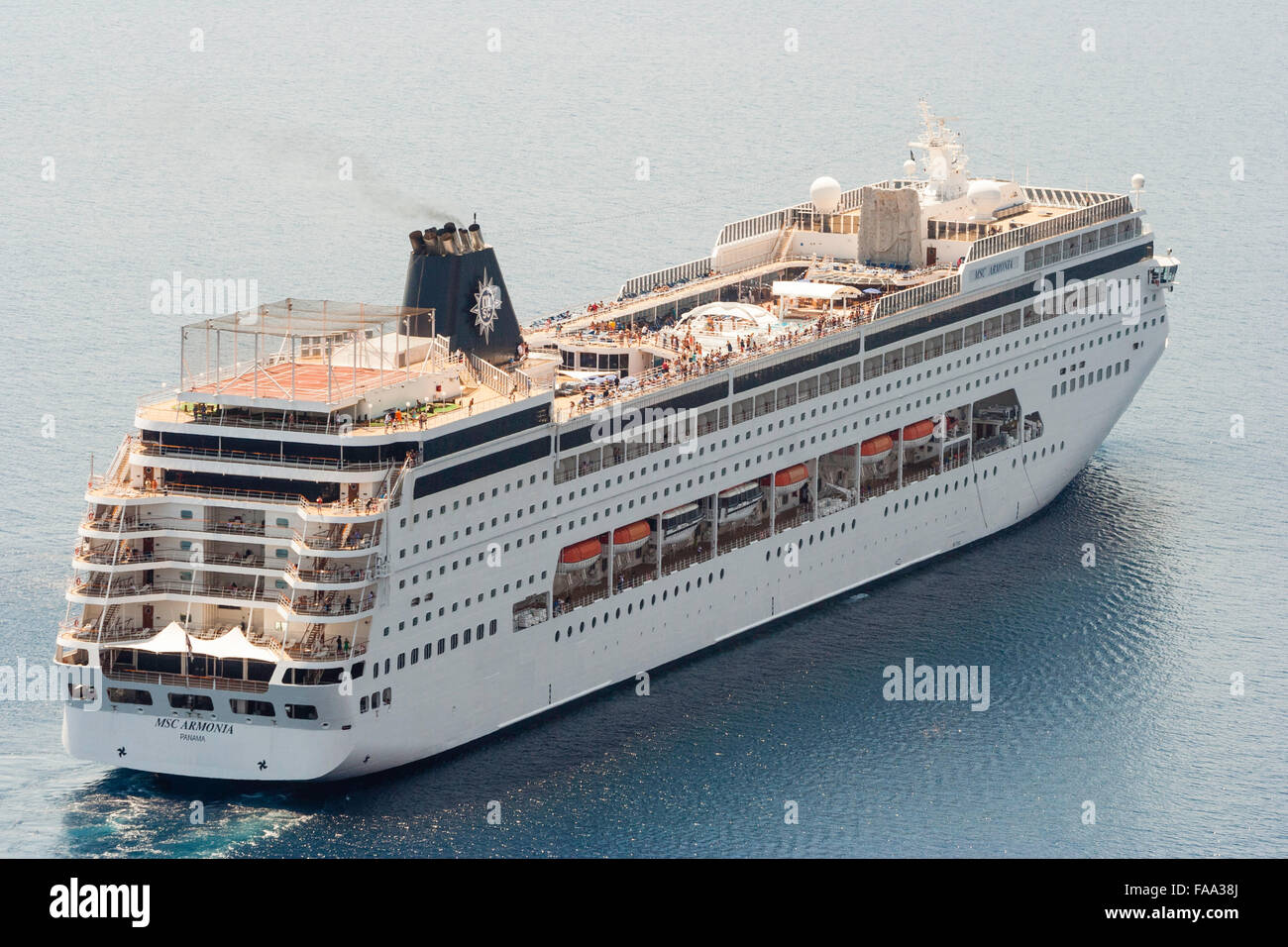 Ägäis, Santorini. Ocean-going Luxus Kreuzfahrtschiff MSC Armonia, voller Menschen, Segeln auf sehr ruhigen Meer. Luftaufnahme, strahlendem Sonnenschein. Stockfoto