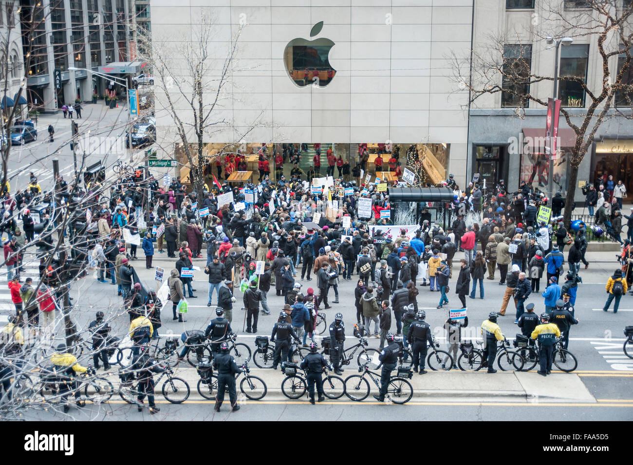 Chicago, USA.  24. Dezember 2015.  Hunderte von Menschen versammeln sich um unten Michigan Avenue "Magnificent Mile" Einkaufsviertel am Heiligabend zum protest gegen die angebliche Polizei vertuschen März im Zusammenhang mit den tödlichen Schüssen auf Laquand McDonald von einem Polizisten in Chicago.  Flankiert von der Polizei von Chicago, wurden Demonstranten skandierten "16 Aufnahmen und ein Cover up" und fordert Chicago Bürgermeister Rahm Emanuel zum Rücktritt auf, was als "Black Christmas" beschrieben. Demonstrationen gezielt große Läden wie im Apple Store, abgebildet.  Bildnachweis: Stephen Chung / Alamy Live News Stockfoto