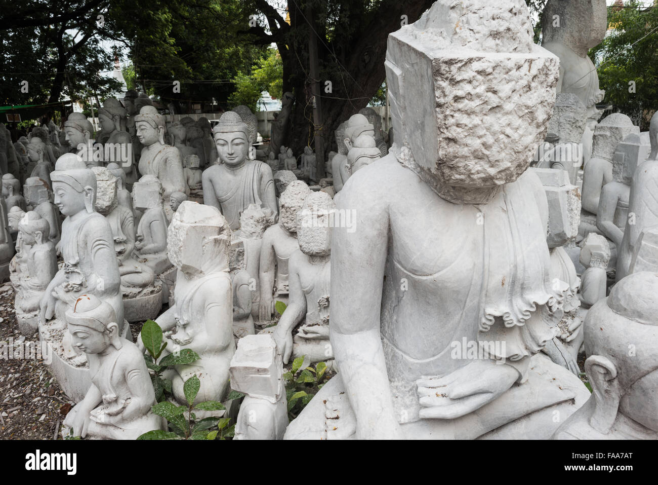 MANDALAY, Myanmar - lokale Handwerker der staubigen und Knochenarbeit der Carving Statuen des Buddha verpflichten sich aus Marmor. Mit dem Buddhismus, die vorherrschende Religion in Myanmar gibt es eine starke Nachfrage für die Statuen, mit Kunden in der Lage, aus einer Vielzahl von Posen, Größen und Stile zu wählen. Die Handwerker sind auf einer Straße in der Nähe von Mandalay Chanmyathazi in der Nähe der Mahamuni Pagode geclustert. Stockfoto