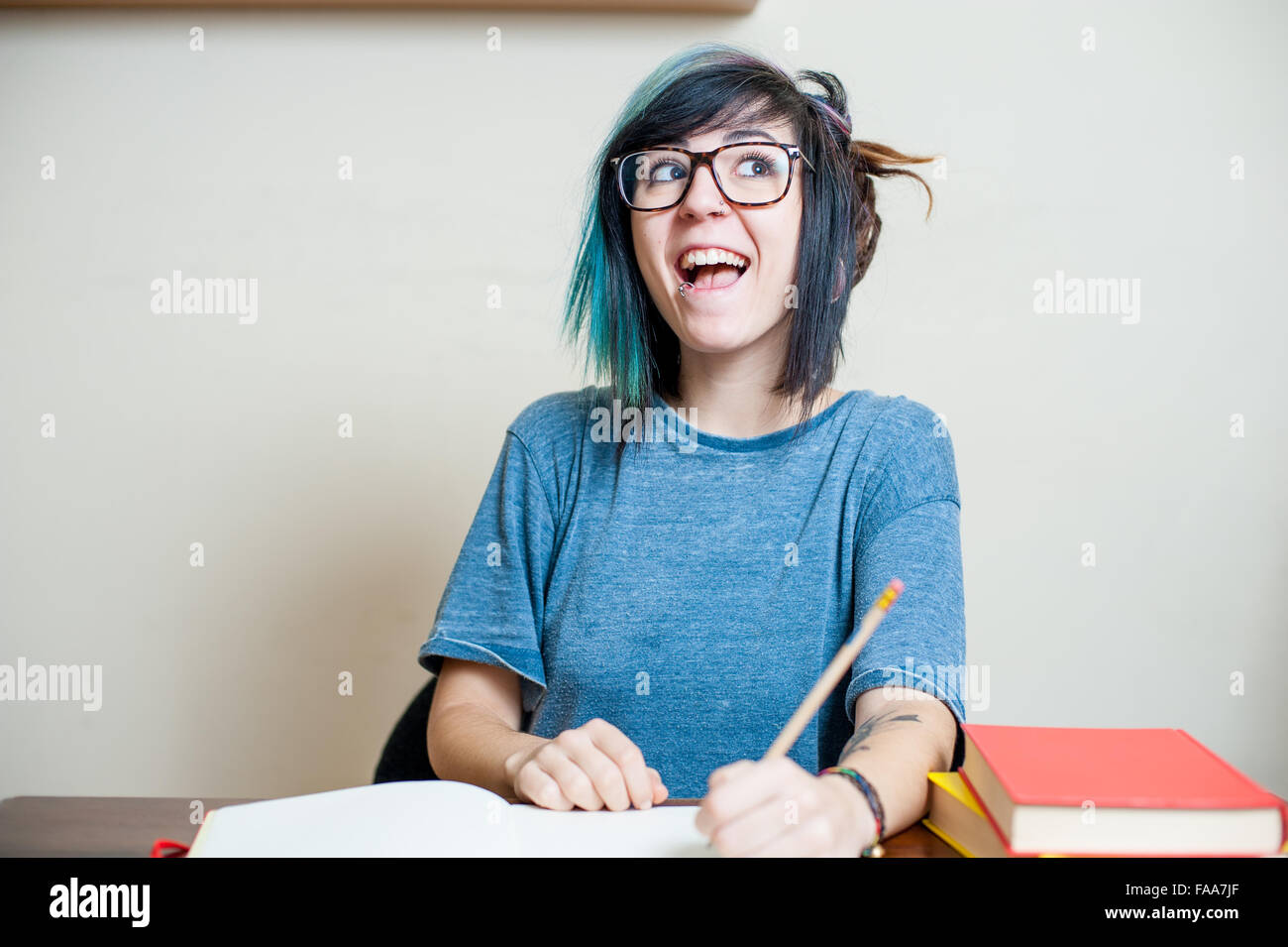 Junge Teen Studentin mit Buch glücklich und lächelnd, wenn das Studium Stockfoto