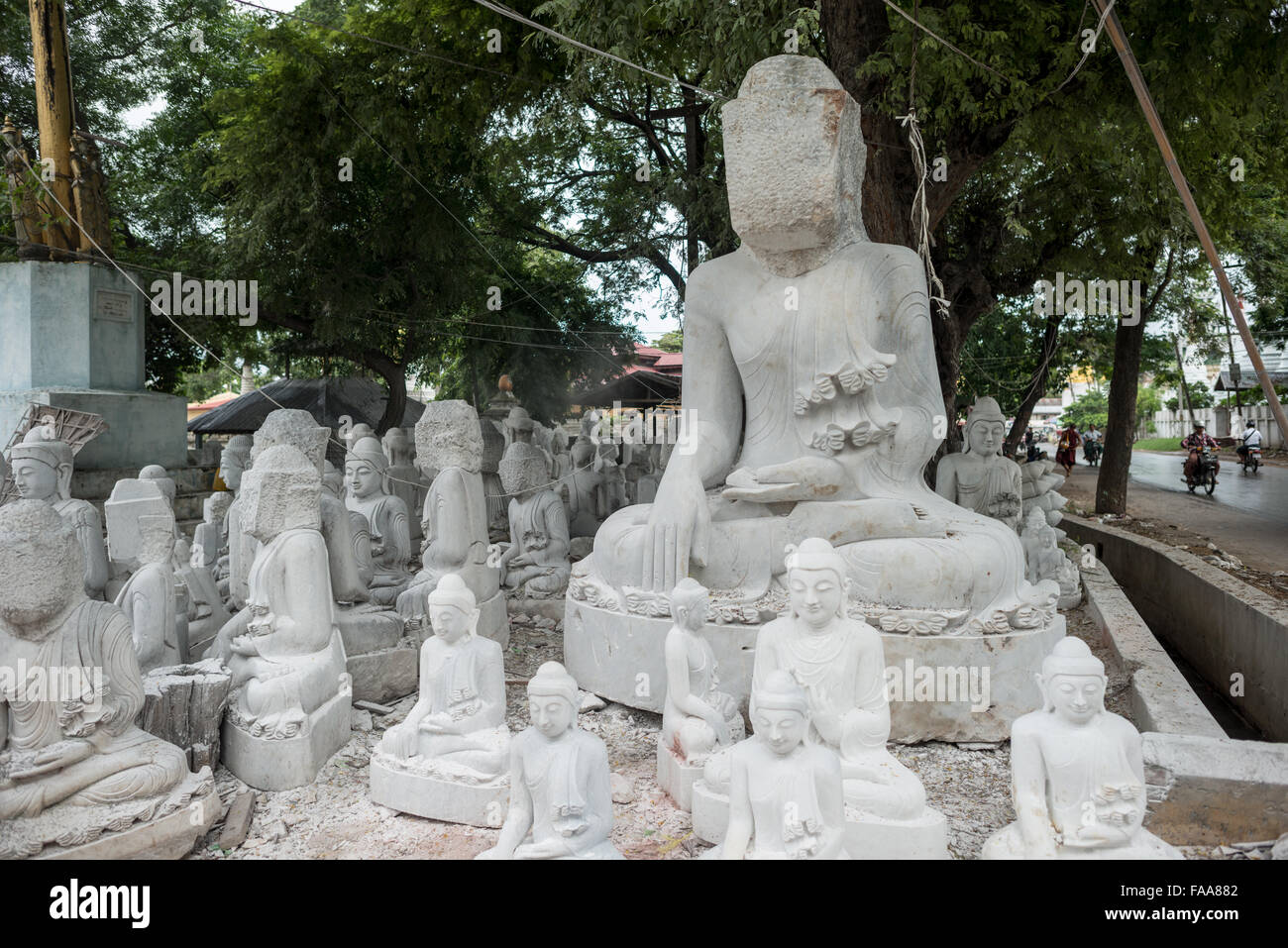MANDALAY, Myanmar - lokale Handwerker der staubigen und Knochenarbeit der Carving Statuen des Buddha verpflichten sich aus Marmor. Mit dem Buddhismus, die vorherrschende Religion in Myanmar gibt es eine starke Nachfrage für die Statuen, mit Kunden in der Lage, aus einer Vielzahl von Posen, Größen und Stile zu wählen. Die Handwerker sind auf einer Straße in der Nähe von Mandalay Chanmyathazi in der Nähe der Mahamuni Pagode geclustert. Stockfoto