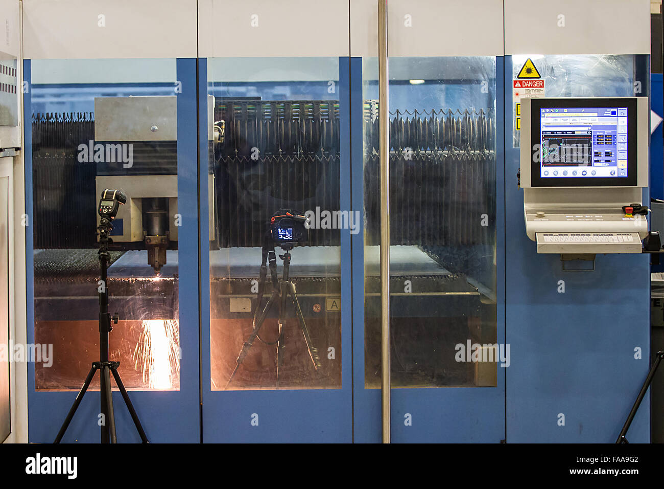 Fotografieren, die Kamera und Blitz fotografieren den CNC-Laser und Computer-Monitor von außen Stockfoto