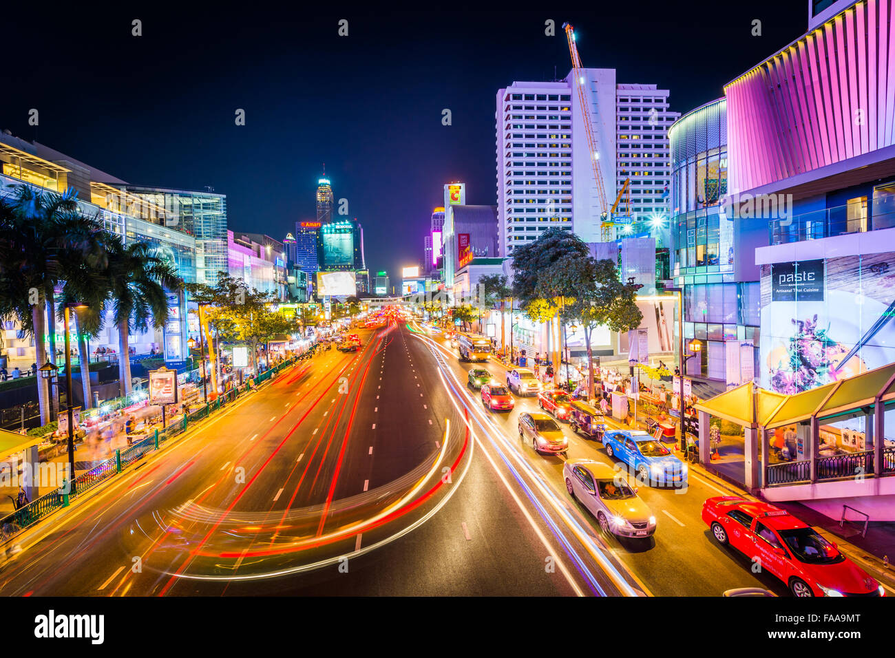 Langzeitbelichtung des Verkehrs und modernen Gebäuden auf Ratchadamri Road in der Nacht, am Siam in Bangkok, Thailand. Stockfoto