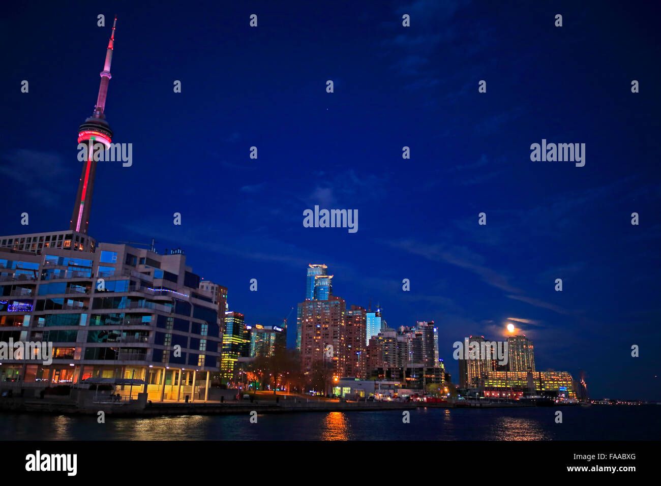 Toronto, Kanada. 24. Dezember 2015. Buckelmond in der Nähe von Vollmond bei 99,7 % steigt über dem Hafen von Toronto mit dem CN Tower und Queens Quay Terminal im Vordergrund am Heiligabend, 24. Dezember 2015 wachsen. Nächsten Vollmond Weihnachten werden 2034, die letzte war im Jahr 1977. Bildnachweis: CharlineXia/Alamy Live-Nachrichten Stockfoto