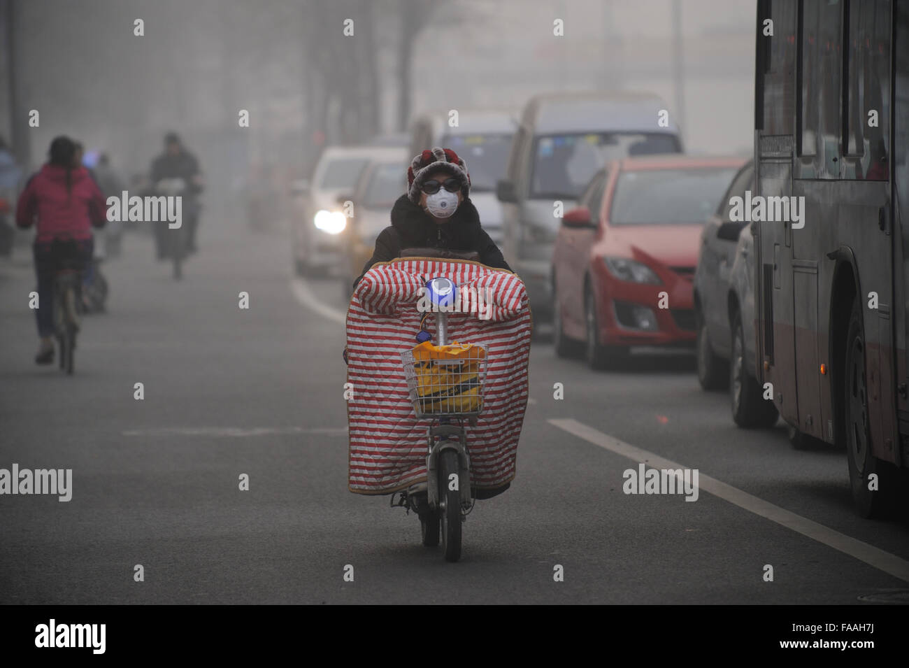 Menschen tragen Masken, wie ein dicker Nebel aus Luftverschmutzung Umschläge Peking, China. 25. Dezember 2015 Stockfoto