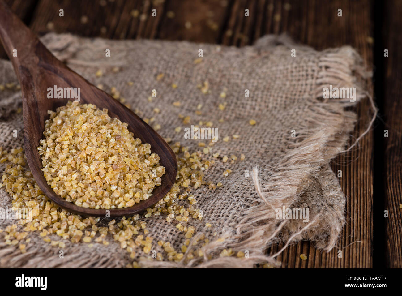 Portion rohen Bulgur (Nahaufnahme) auf hölzernen Hintergrund Stockfoto