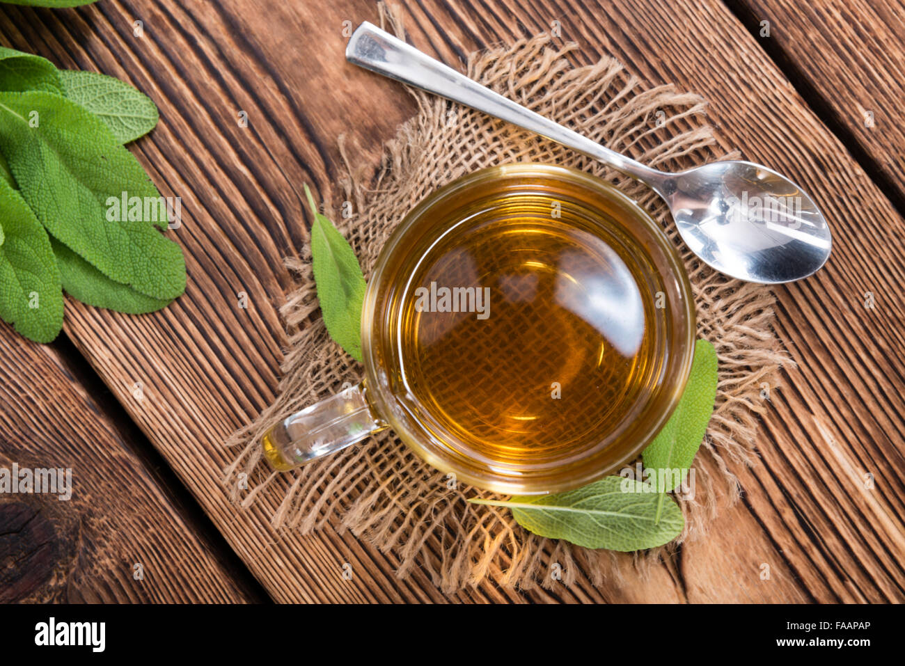 Salbei Tee in einem kleinen Glas auf hölzernen Hintergrund Stockfoto