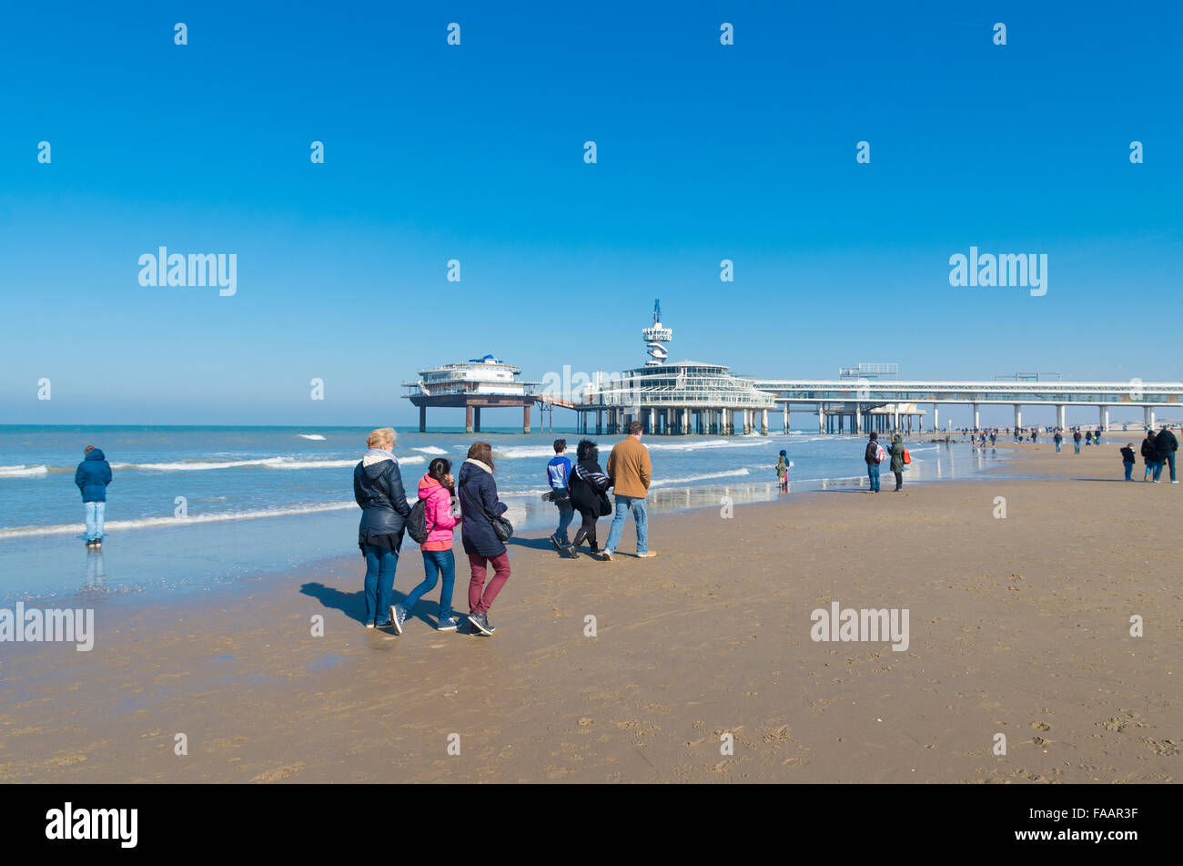 SCHEVENINGEN, Niederlande - 8. März 2015: Unbekannte Menschen genießen einen sonnigen Frühlingstag am Nordseestrand. Im Hintergrund Stockfoto