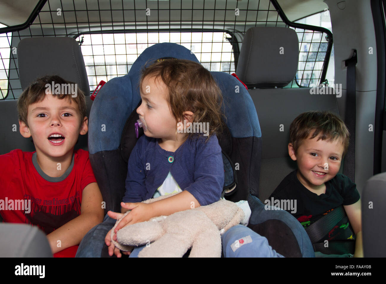Drei Kinder auf der Rückseite ein SUV-Auto. Stockfoto