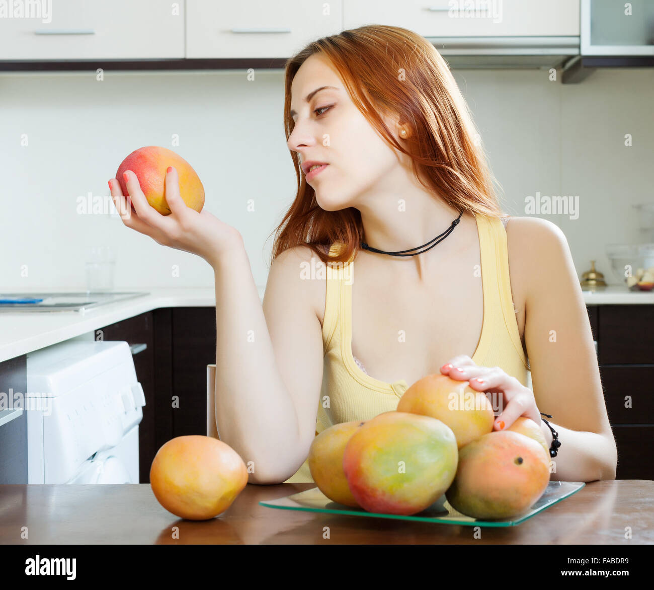 gewöhnliche Frau, die Mango zu Hause Küche Stockfoto