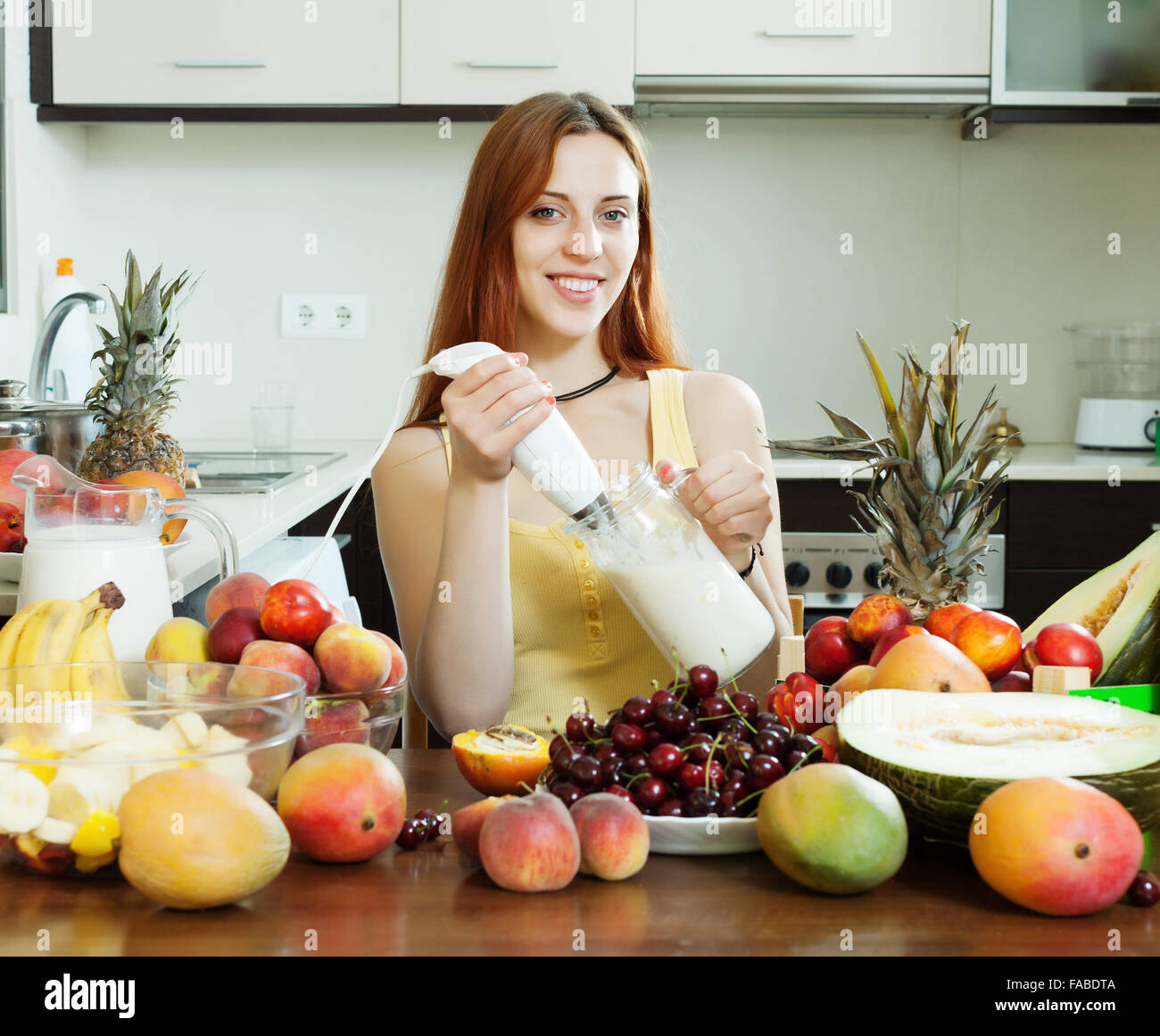 Frau macht frischen Milch cocktail mit Blender aus Früchten am heimischen Küche Stockfoto