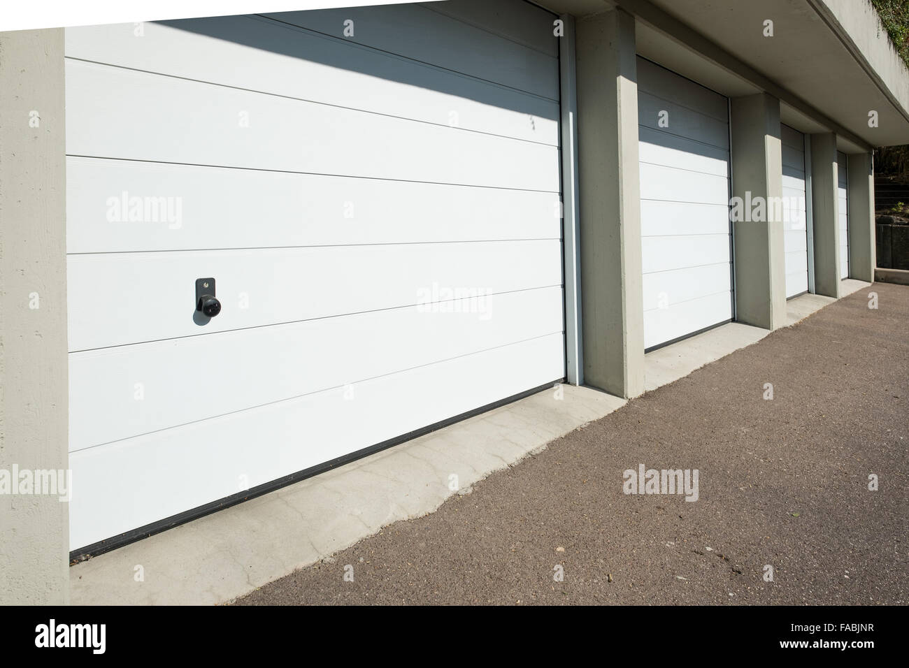 Weiße Garagentore mit Knopf in einem Eintrag Stockfoto