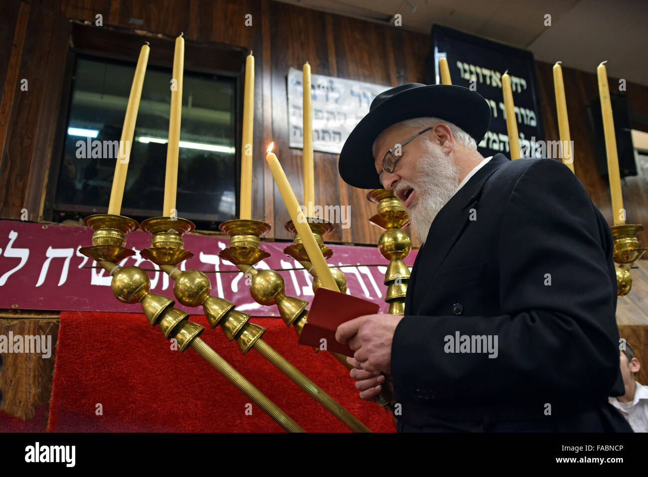 Eine orthodoxe jüdische Rabbiner rezitieren die Segen vor dem Anzünden der Kerzen auf eine riesige Chanukka Menora. In Brooklyn, New York Stockfoto