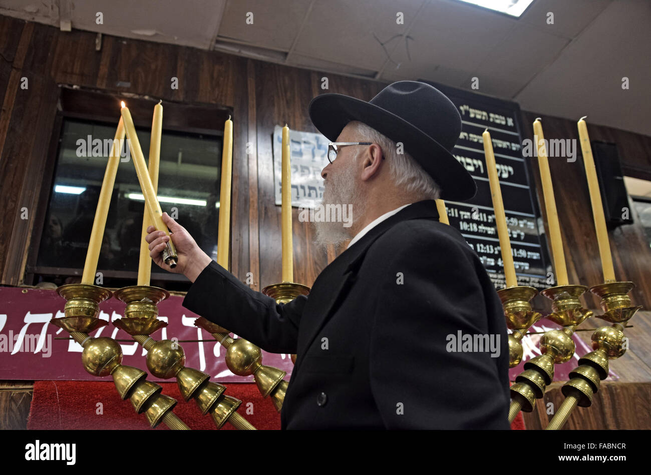 Eine orthodoxe jüdische Rabbiner Anzünden der Kerzen auf eine riesige Chanukka Menora. In Brooklyn, New York Stockfoto