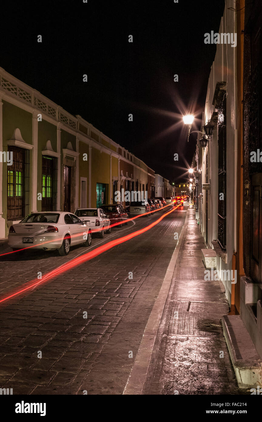 Nachtaufnahme der Rücklichter, die einen langen roten Rücklichtweg entlang einer Straße in der historischen Stadt Campeche in Yucatan, Mexiko, schaffen. Stockfoto