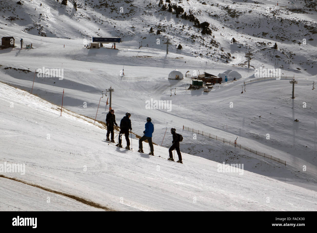 Vier Skifahrer in schwarz mit Blick auf Skipisten, Andorra Stockfoto