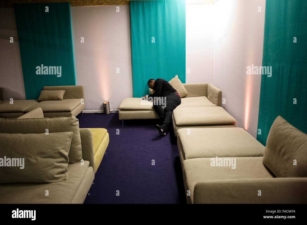 Ein erschöpft Delegierter der COP21 United Nations Climate Change Conference schläft auf der Couch nach längere Verhandlungen weiterhin 7. Dezember 2015 in Le Bourget, Frankreich. Stockfoto