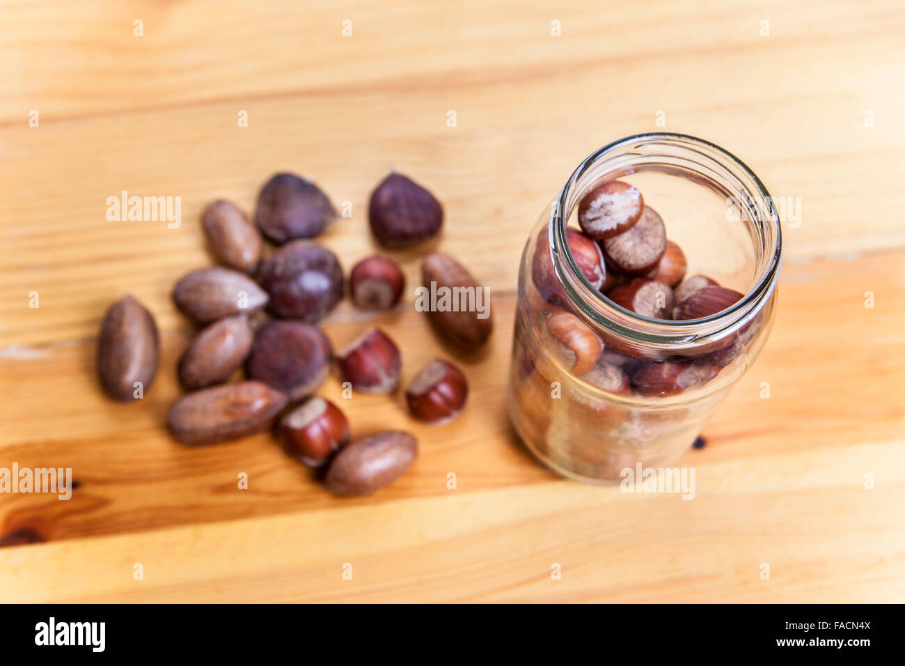 Pecan-Nüssen und Haselnuss auf Glas jar über Holzoberfläche. Hohen Winkel gedreht Stockfoto
