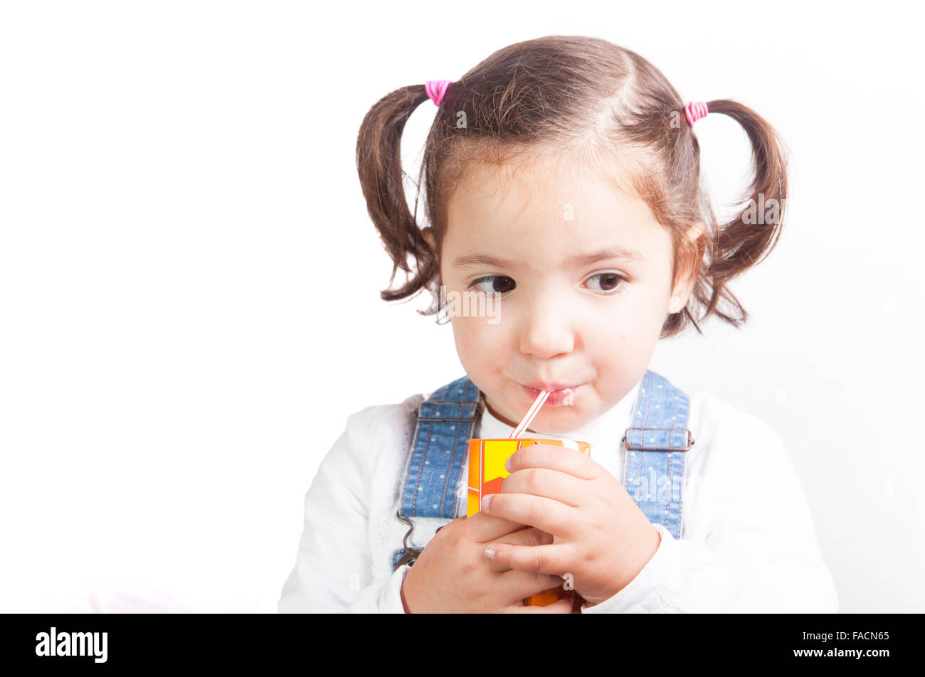 Porträt von glücklichen Mädchen trinken einen Fruchtsaft aus dem Ziegel. Isoliert auf weißem Hintergrund Stockfoto