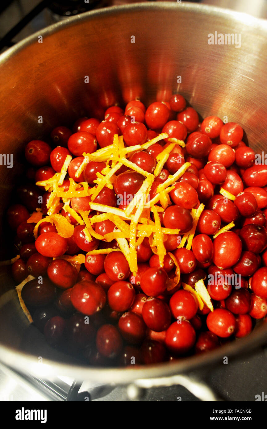 Frische Cranberries mit Orangenschale in einem Topf bereit, Cranberry-Sauce zu Weihnachten zu machen Stockfoto