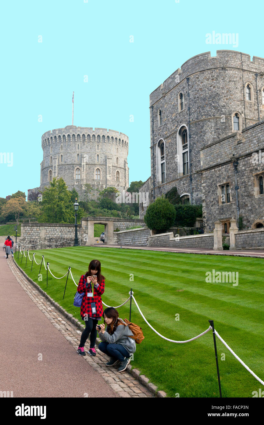 Japanische Touristen überprüfen ihre Handys vor dem Rundturm an Windsor Castle, Berkshire, England, UK Stockfoto