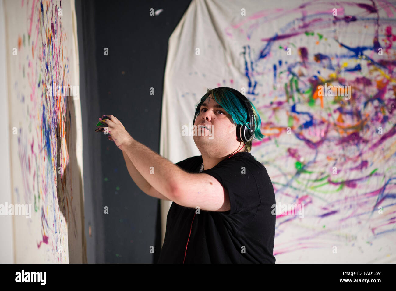 Kunstvermittlung in Großbritannien: ein junger männlicher Student schaffen ein Stück live Performance-Kunst Aktion Fingermalerei während einer Ausstellung der Arbeiten von Studenten der bildenden Kunst in einer Galerie an der School of Art, Aberystwyth University Wales UK Stockfoto