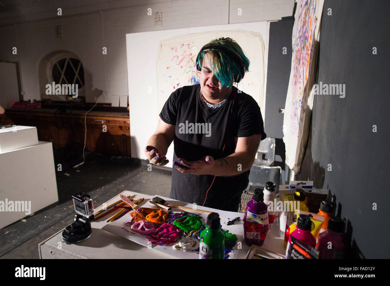 Kunstvermittlung in Großbritannien: ein junger männlicher Student schaffen ein Stück live Performance-Kunst Aktion Fingermalerei während einer Ausstellung der Arbeiten von Studenten der bildenden Kunst in einer Galerie an der School of Art, Aberystwyth University Wales UK Stockfoto