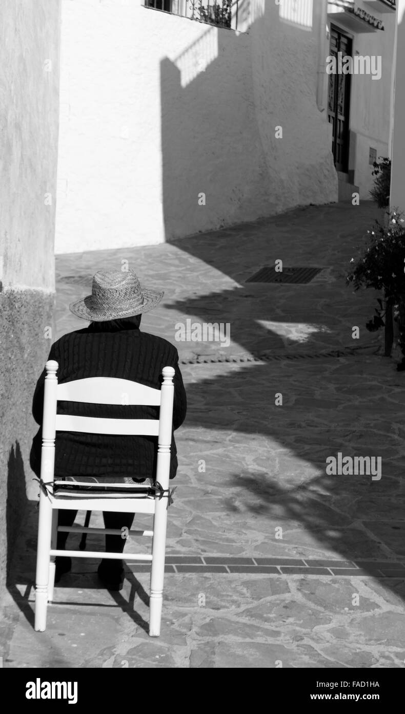 Rückansicht der spanische Dame saß auf einem Stuhl vor ihrem Haus in dem Dorf Totalan, Málaga, Südspanien. Stockfoto