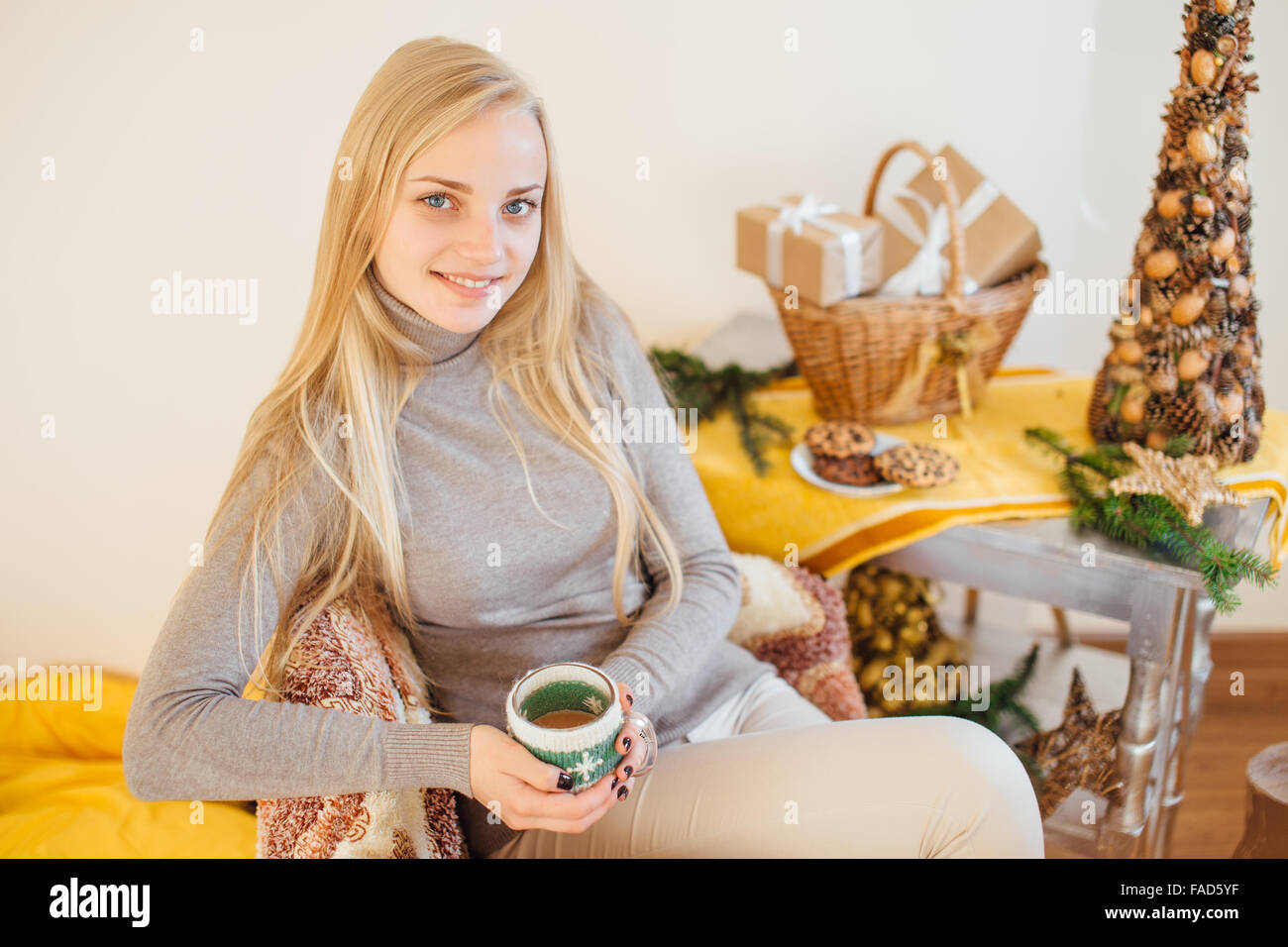 Blondes Mädchen trinken ihren Kaffee, esse Kekse und ein Buch lesen Stockfoto