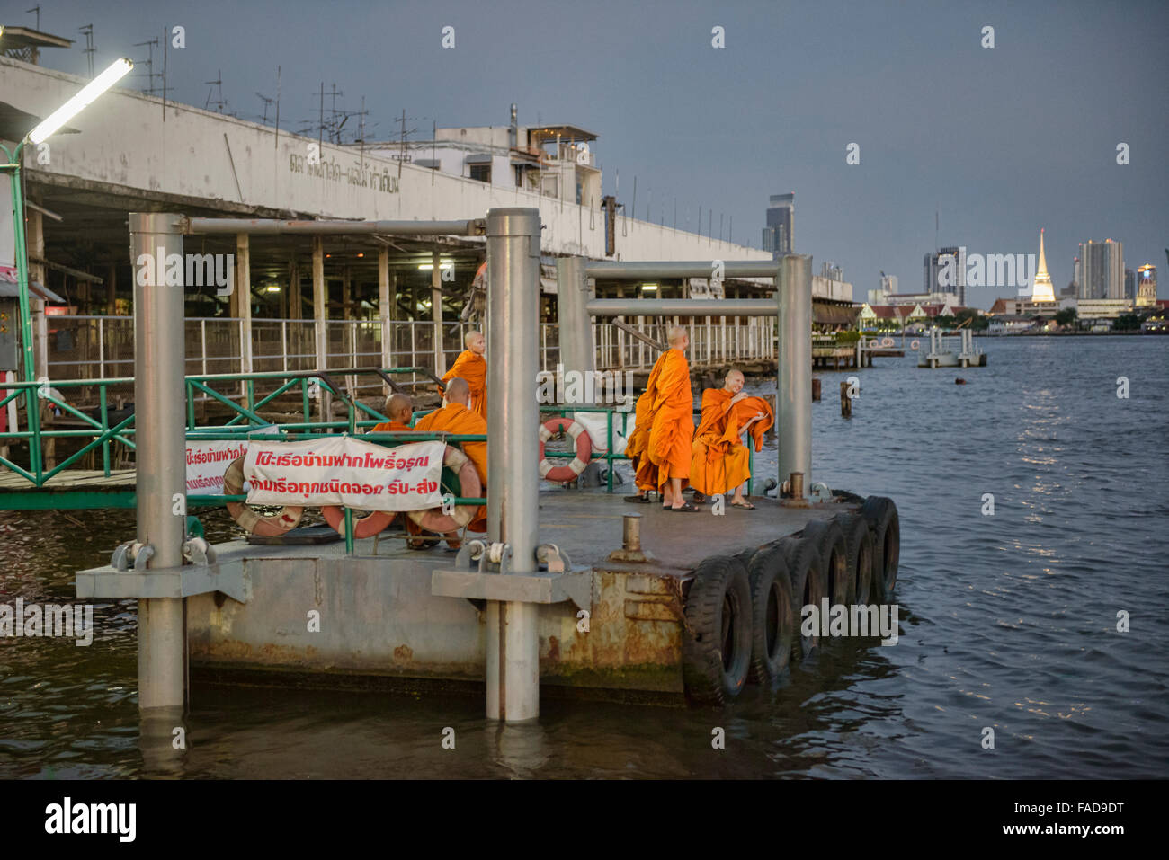 Mönche, die warten auf ein Boot auf dem Chao Phraya River in Bangkok, Thailand Stockfoto