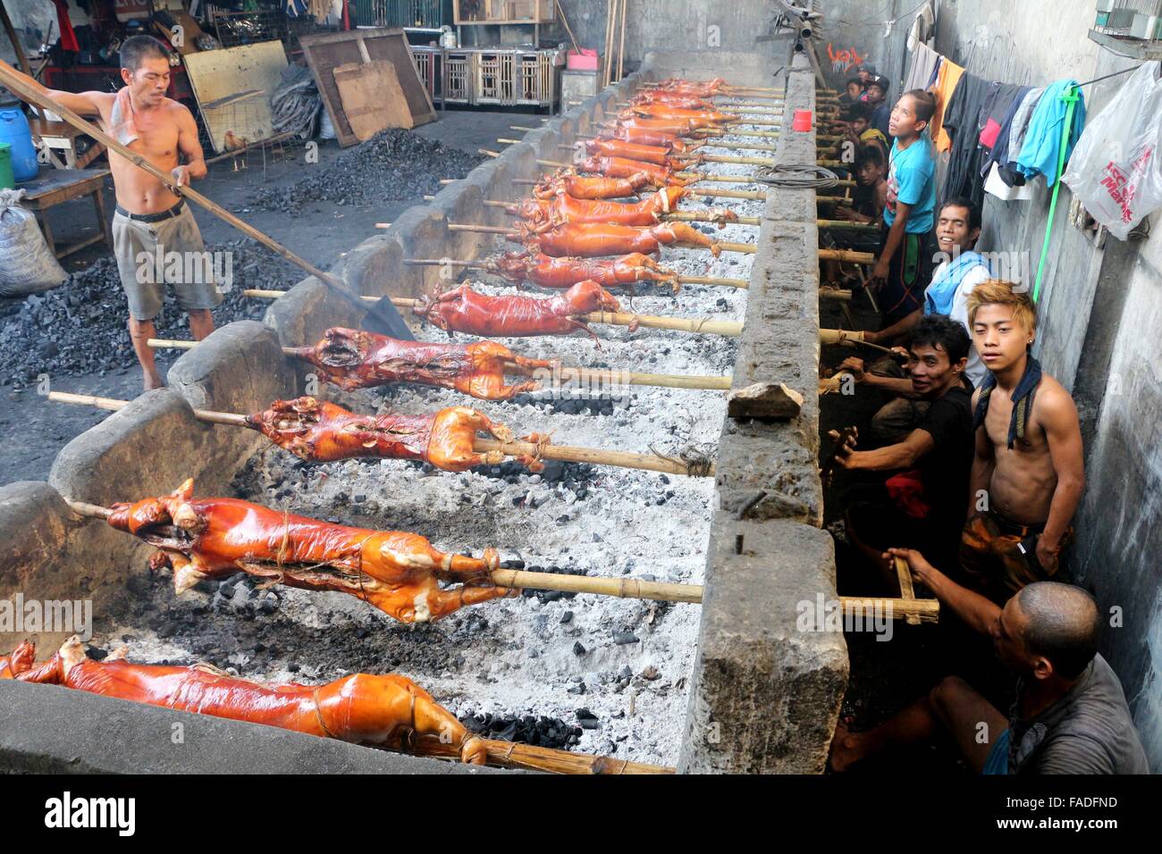 Arbeiter der Laloma in Quezon City (die Lechon Hauptstadt der Philippinen) bereitet die Lechon Baboy (gebratenes Schweinefleisch), die für die kommende Feier der Noche Buena oder Silvester Feier zur Abholung bereitstehen, nach der Lechonero (gebratenes Schweinefleisch kochen) kochen sie gebratene Schweinefleisch von 2 bis 3 Stunden, es hängt immer noch über die Größen und sie kochen es in traditionelle Weise oder manuelle Drehung des Schweinefleisches. Die Preise der Lechon Baboy (gebratenes Schweinefleisch) beginnen bei 4,00 Pesos bis zu 15.000 pro. (Foto von Gregorio B. Dantes Jr. / Pacific Press) Stockfoto