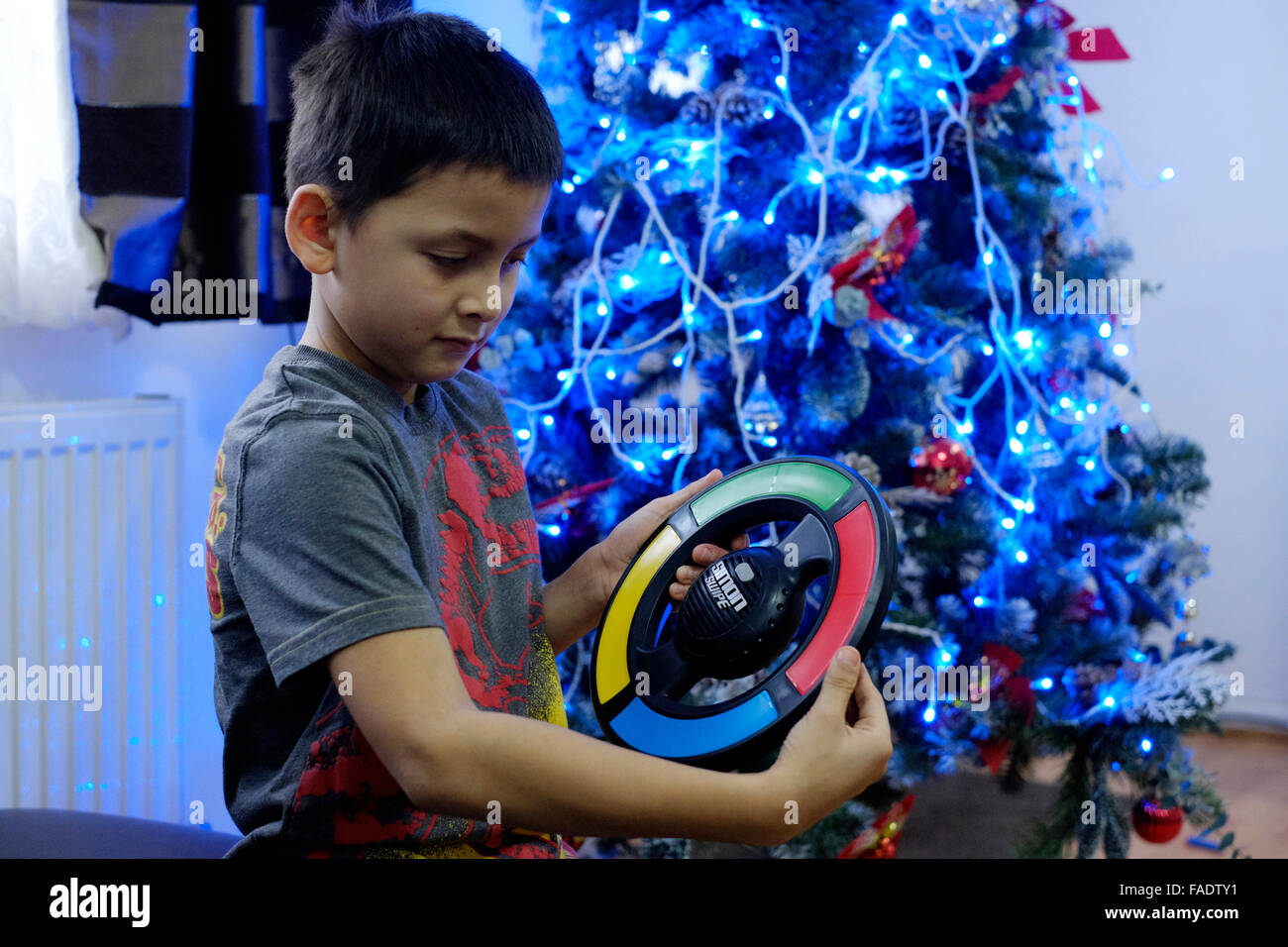 kleiner Junge spielt elektronische Spiel Weihnachtsbaum in England uk Stockfoto