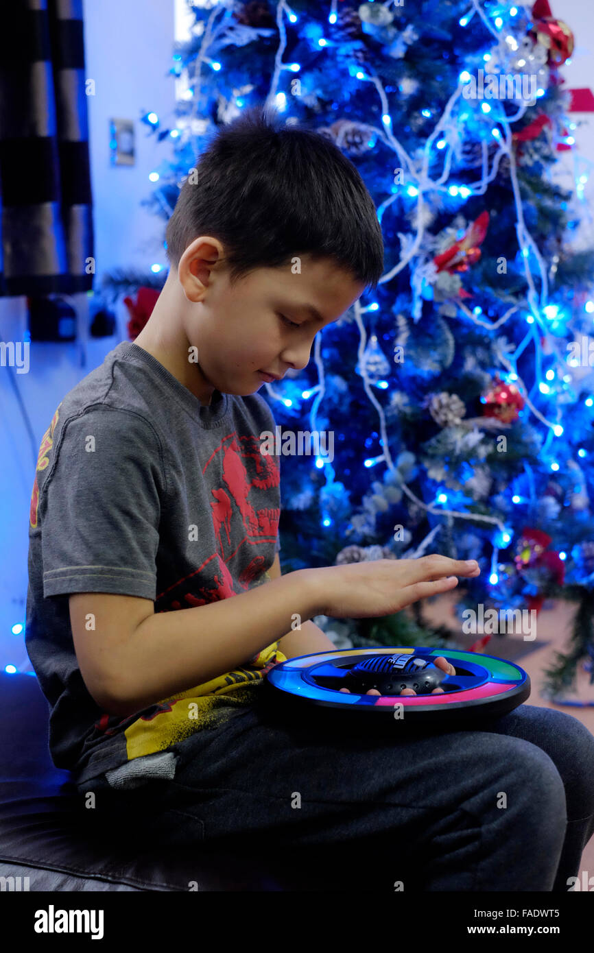 kleiner Junge spielt elektronische Spiel Weihnachtsbaum in England uk Stockfoto
